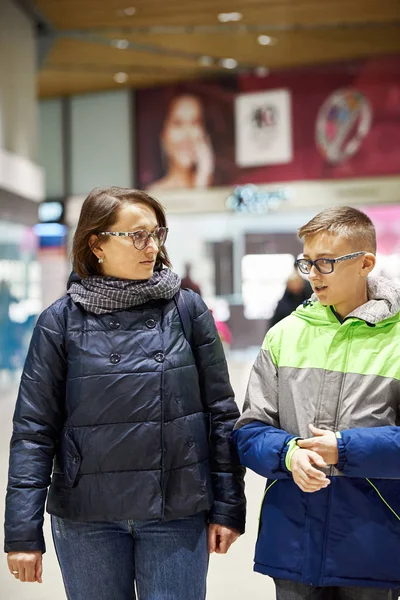 Mom and son in jackets are talking in the mall. — 스톡 사진