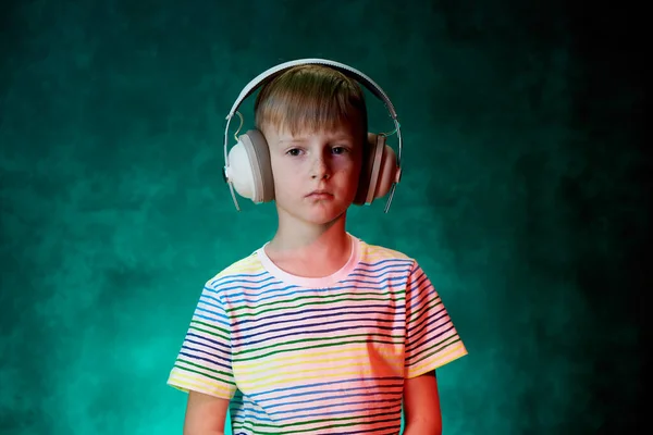 Το αγοράκι ακούει την αγαπημένη του μουσική με σύγχρονα ασύρματα ακουστικά, στο στούντιο — Φωτογραφία Αρχείου