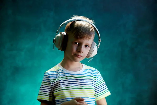 Το αγοράκι ακούει την αγαπημένη του μουσική με σύγχρονα ασύρματα ακουστικά, στο στούντιο — Φωτογραφία Αρχείου