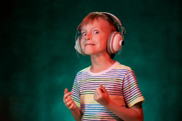 Pequeño niño escucha su música rock favorita en los auriculares inalámbricos modernos, en el estudio —  Fotos de Stock