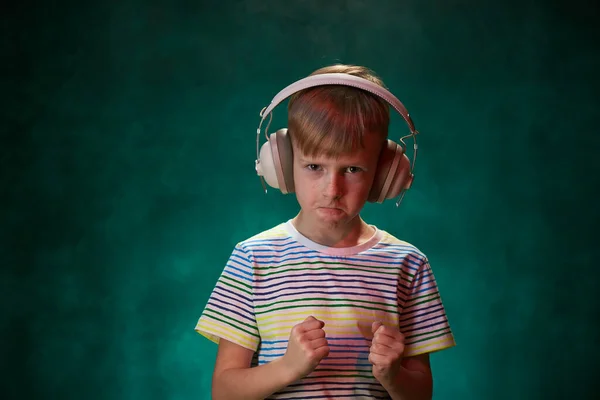 Liten pojke lyssnar på sin favoritmusik i moderna trådlösa hörlurar, i studion — Stockfoto