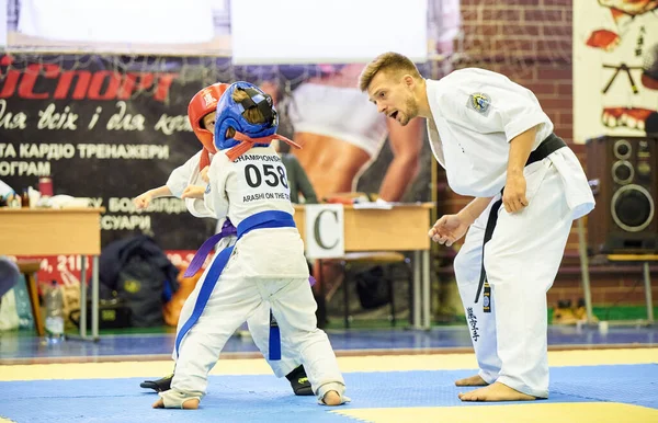 16 / 11 / 2019 Kiev, Ucrânia As crianças estão envolvidas na seção Arashi Karate. Treino luta entre meninos em capacetes e kimano. — Fotografia de Stock