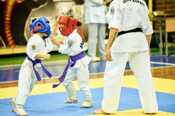 16 / 11 / 2019 Kiev, Ucrânia As crianças estão envolvidas na seção Arashi Karate. Treino luta entre meninos em capacetes e kimano. — Fotografia de Stock