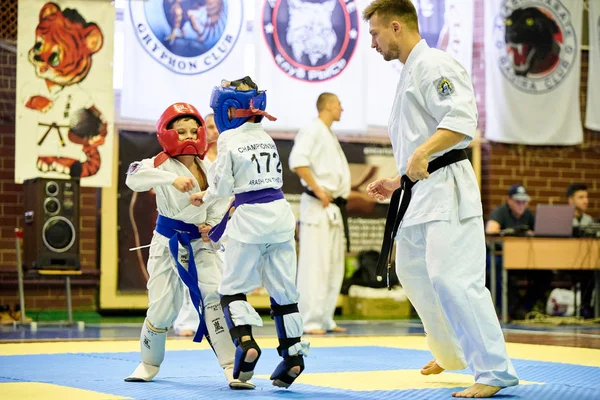 16 / 11 / 2019 Kiev, Ucrânia As crianças estão envolvidas na seção Arashi Karate. Treino luta entre meninos em capacetes e kimano. — Fotografia de Stock