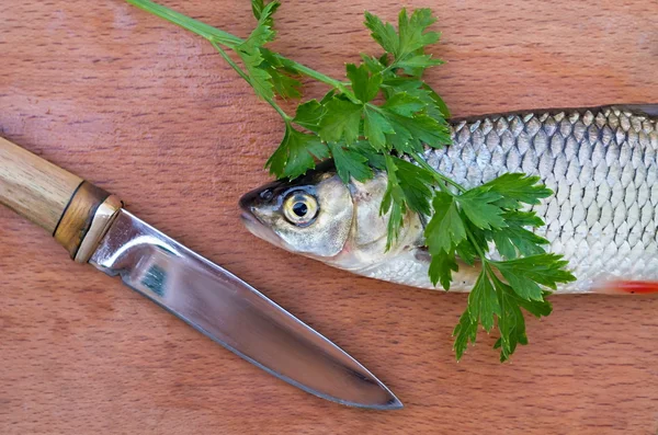 fish, parsley leaves and carving knife