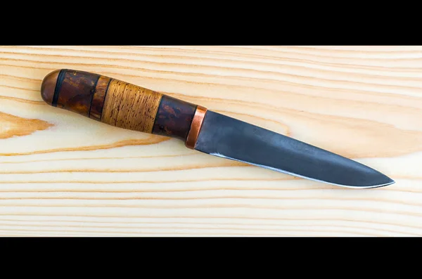 Lovecký nůž ležící na desce — Stock fotografie