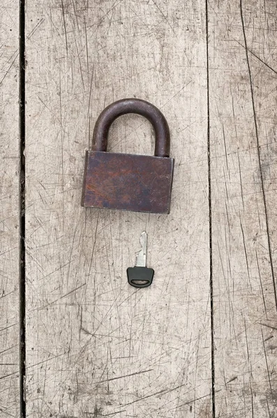 Vieja cerradura y llave moderna sobre un fondo de madera, tonificación retro — Foto de Stock