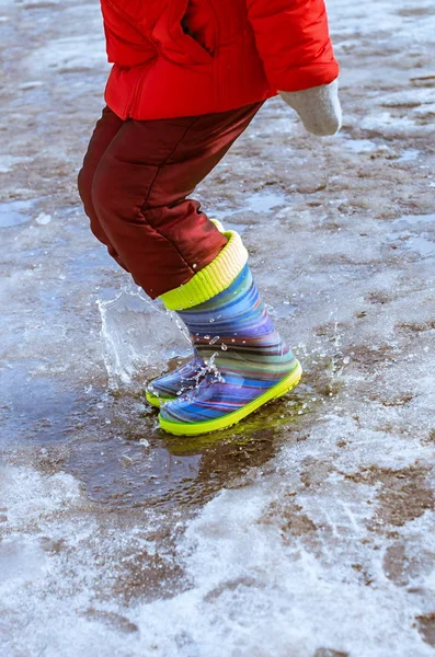 Feet in rubber boots jumping in puddle — Stock Photo, Image