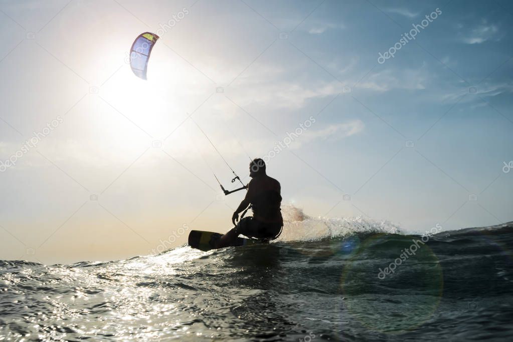 Kite surfer sailing in front of the sunset