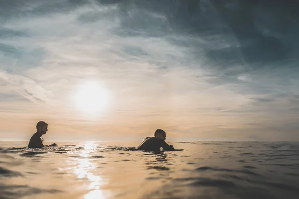 Δύο surfers, περιμένοντας ένα κύμα στο ηλιοβασίλεμα — Φωτογραφία Αρχείου