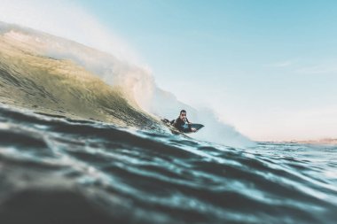 Genç adam bodyboarding büyük bir dalga