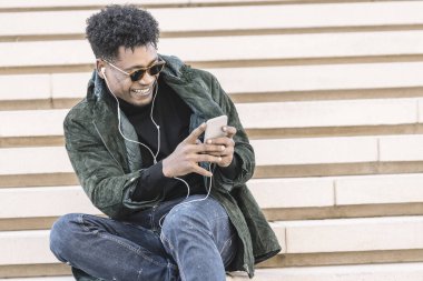 Afrikalı bir adam kulaklıkla video görüşmesi yapıyor.