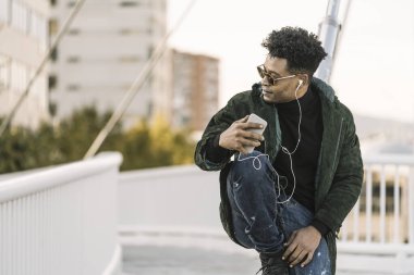 Güneş gözlüklü Afrikalı siyahi adam müzik dinliyor