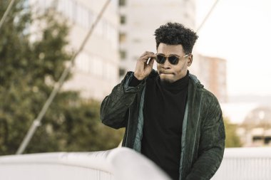 Yakışıklı genç siyah adam şehrin yanından geçiyor.