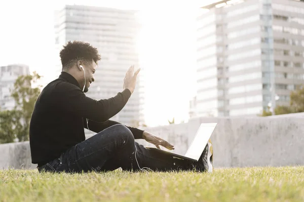 black man laughing making a video call with laptop