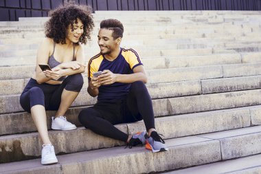 Spor uygulamasına bakan mutlu atletik genç çift