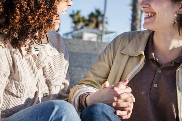 Dettaglio di un paio di donne che ridono tenendosi per mano — Foto Stock