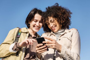 İki kadın telefonda eğleniyor.