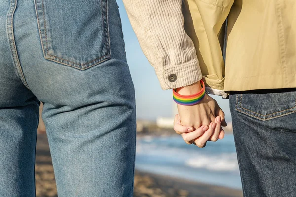 Linked hands with rainbow flag bracelet — 스톡 사진