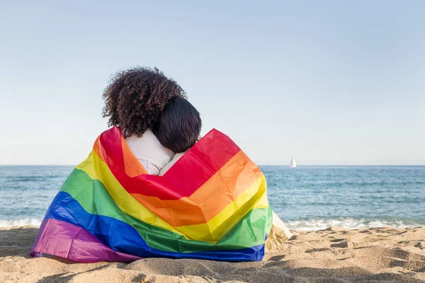 Women in love relaxing wrapped in the rainbow flag — Stock fotografie