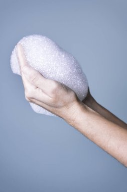 Mavi zemin üzerinde köpük toplu eller, virüs önleme, hijyen ve cilt bakımı konsepti, metin alanı için fotokopi alanı olan dikey fotoğraf