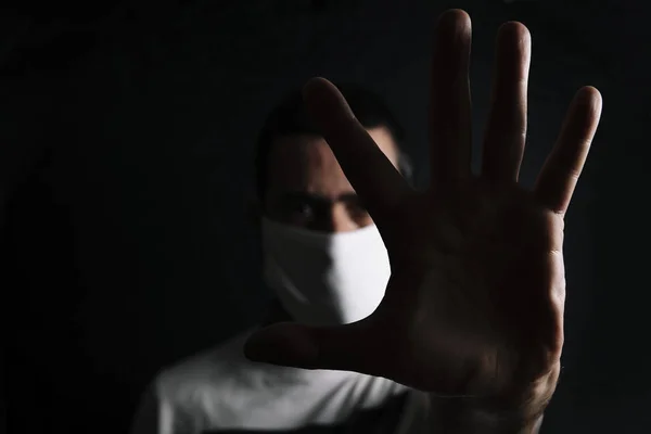Ciemny Portret Mężczyzny Masce Ochronnej Robiącego Znak Stopu Ręką Czarnym — Zdjęcie stockowe