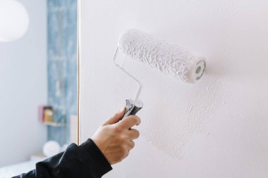 Duvarı beyaza boyarken silindir, ev dekorasyonu ve yenileme konsepti, yatay fotoğraf