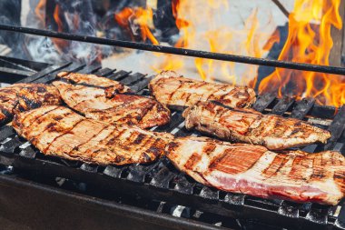 Yanan ızgarada biftek, barbekü konsepti ve dışarıda arkadaşlarla yemek pişirmek.