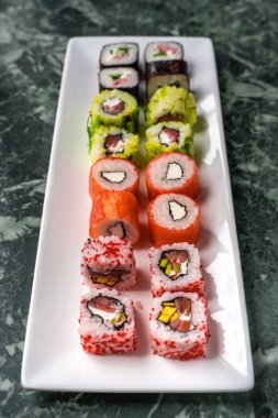 Beyaz tabakta taze yapılmış suşi.