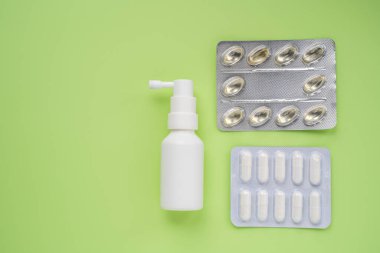 Ayağında su toplamış farklı haplar ve ilaçlarla dolu sprey bir şişe. Sağlık ilaçları.