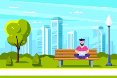 Parktaki genç adam dizüstü bilgisayarla çalışıyor..