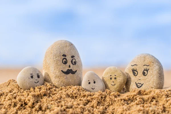모래에 얼굴이 그려진 돌들이 아버지 어머니 그리고 자녀들 가족에 — 스톡 사진