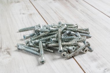 Tahta arka planda monte edilen mobilyalar için vida cıvataları grubu. Stok fotoğrafı.