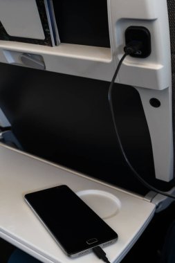 Seyahat ederken elektronik cihazları şarj etmek için USB girişi. Gemide bir cep telefonu şarj ediliyor. Stok fotoğrafı