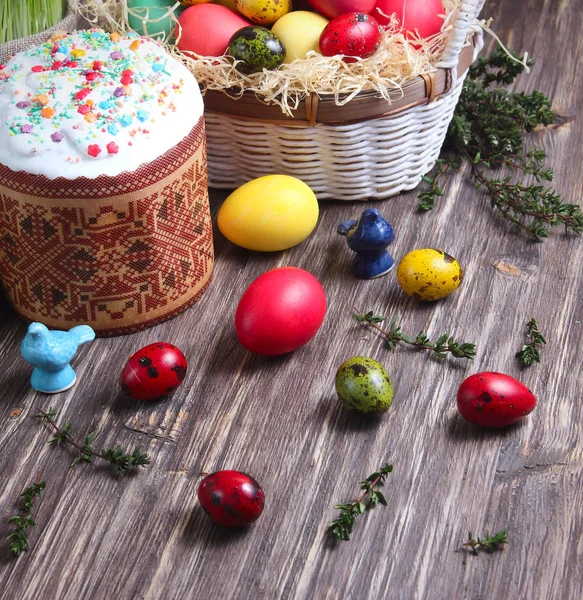 Ciasto wielkanocne i kolorowe jajka na podłoże drewniane — Zdjęcie stockowe