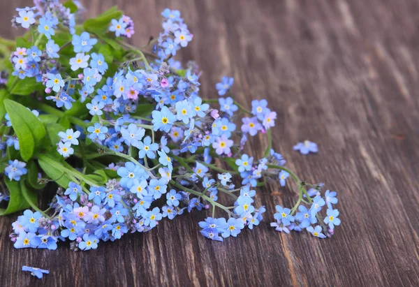 Boeket van blauwe forget-me-nots op een houten achtergrond — Stockfoto