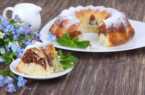 Pedaços de bolo de mármore polvilhado com açúcar em pó e flores — Fotografia de Stock