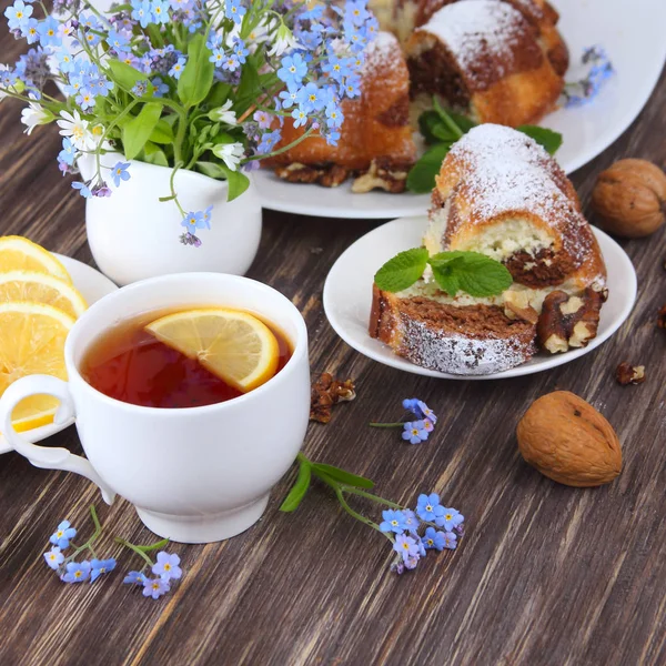 Cupcake und Tee mit Blumen auf Holzgrund — Stockfoto