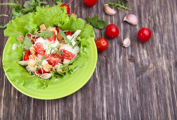 Comestibles de verduras en una mesa de cocina de madera - tomates, tomates cherry, ajo, lechuga y rúcula — Foto de Stock