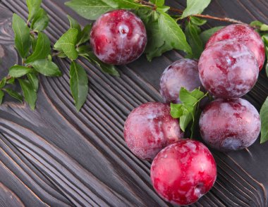 Koyu ahşap arka plan üzerinde olgunlaşmış mavi Erik