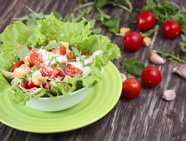 Salada Caesar e tomates frescos em uma mesa de madeira — Fotografia de Stock