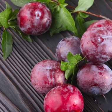 Koyu ahşap arka plan üzerinde olgunlaşmış mavi Erik