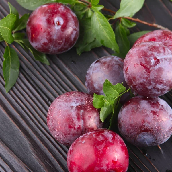 Koyu ahşap arka plan üzerinde olgunlaşmış mavi Erik