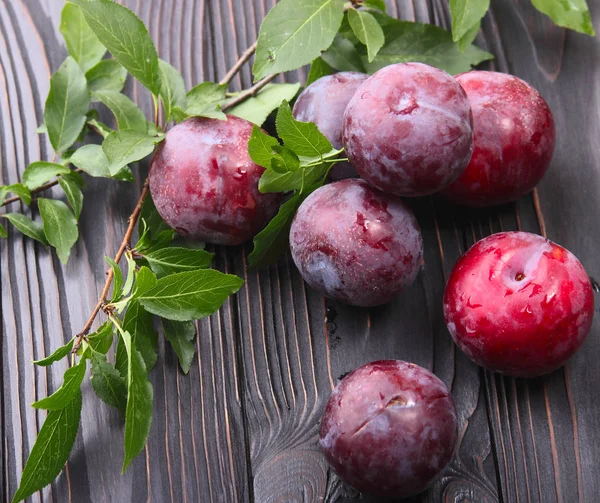 Koyu ahşap arka plan üzerinde olgunlaşmış mavi Erik