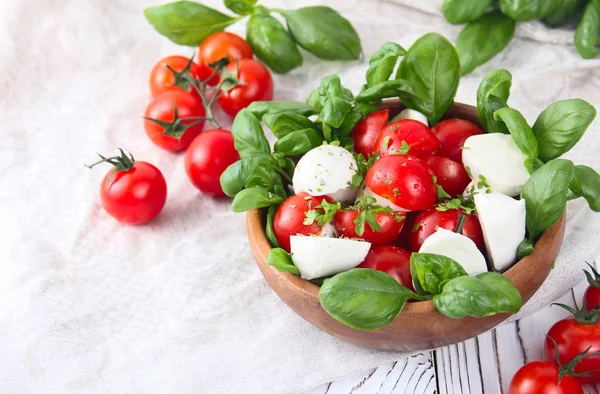 Tomater och mozzarella i en skål, italiensk mat på ett träd — Stockfoto