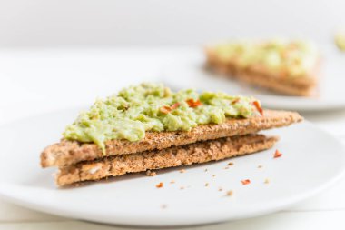 Wholemeal Bread Toast with mashed avocado and chilli flakes clipart
