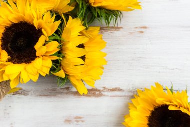 Beyaz rustik zemin üzerine sarı ayçiçeği buket