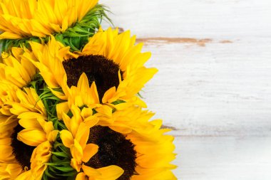 Beyaz rustik zemin üzerine sarı ayçiçeği buket