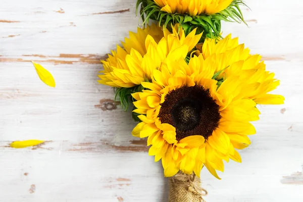 Beyaz rustik zemin üzerine sarı ayçiçeği buket