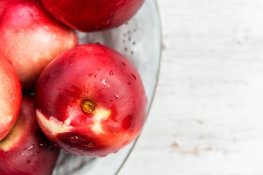 Rustik seramik tabak içinde taze nektarin